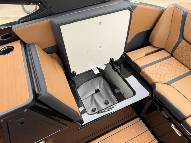 Slide: The Image of 2025 Yamaha Boats 255XD interior storage compartment with tan and black seating. - 42