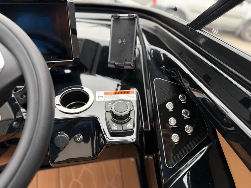 Slide: The Image of 2025 Yamaha Boats 255XD dashboard with control panel and smartphone holder. - 53
