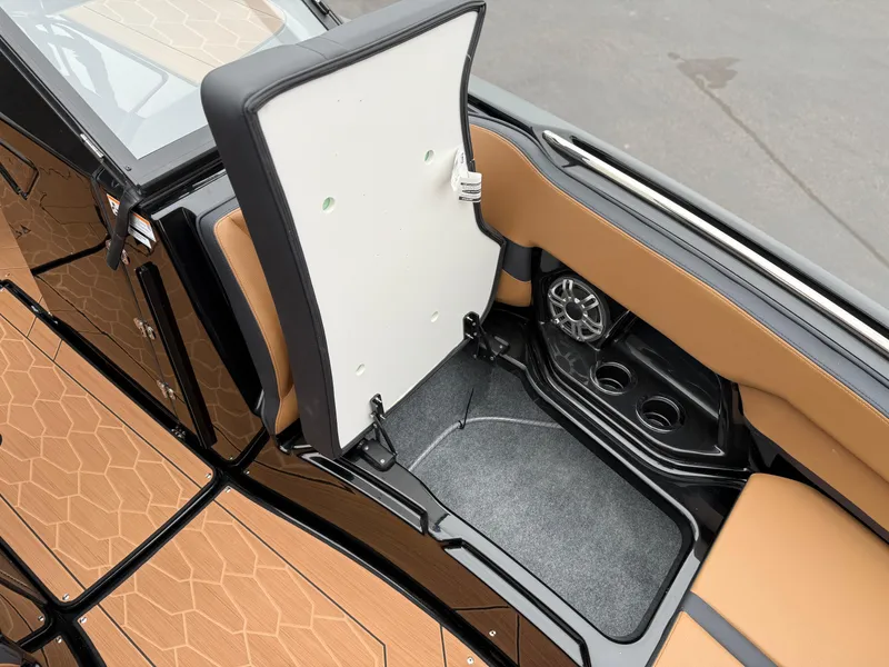 Slide: The Image of 2025 Yamaha Boats 255XD interior storage compartment with cup holders and speaker. - 68