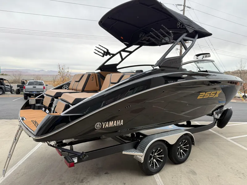Slide: The Image of 2025 Yamaha Boats 255XD on trailer, sleek black design, modern features, outdoor setting. - 7
