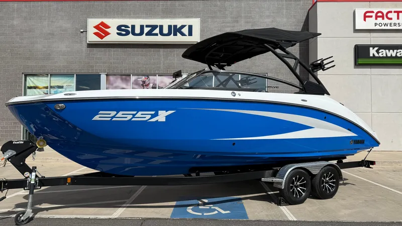 Slide: The Image of 2025 Yamaha Boats 255XD in blue on a trailer, parked outside a dealership. - 10