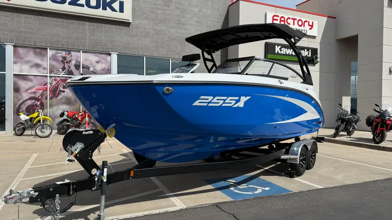 Slide: The Image of 2025 Yamaha Boats 255XD in blue, displayed on a trailer outside a dealership. - 11