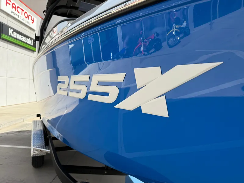 Slide: The Image of 2025 Yamaha Boats 255XD, blue hull with bold "255X" logo, displayed at dealership. - 14