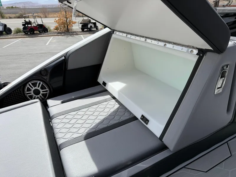 Slide: The Image of 2025 Yamaha Boats 255XD storage compartment with open lid, showcasing spacious interior design. - 26