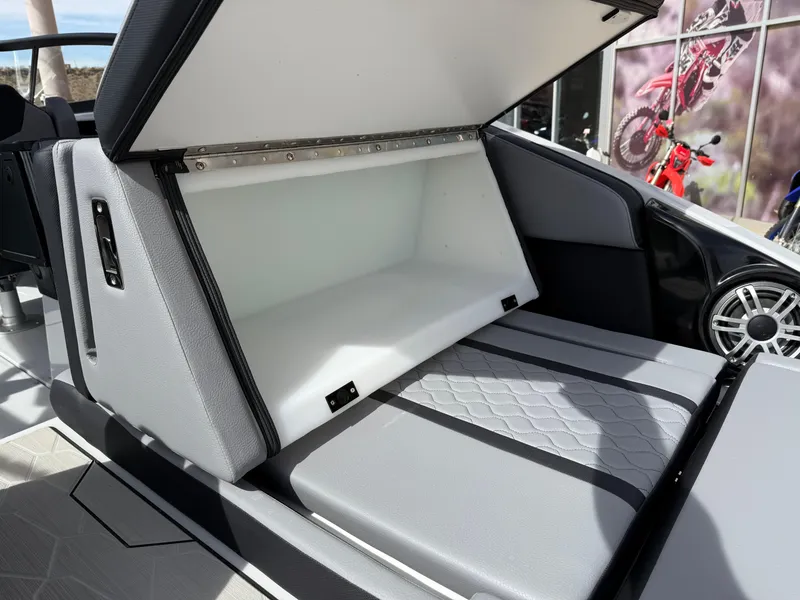 Slide: The Image of 2025 Yamaha Boats 255XD storage compartment with open lid, showcasing spacious interior. - 27
