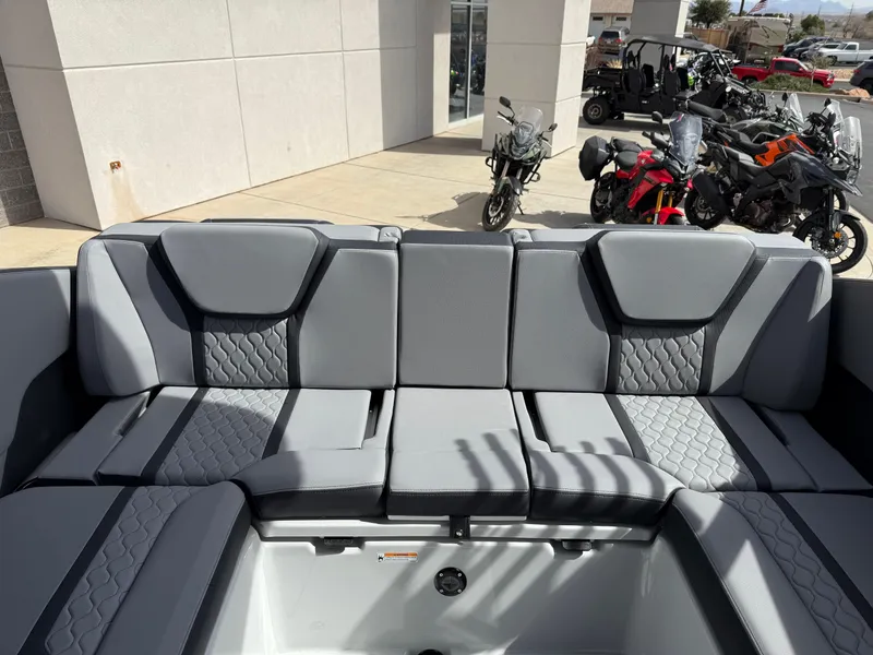 Slide: The Image of 2025 Yamaha Boats 255XD interior seating with modern design, parked motorcycles in the background. - 28