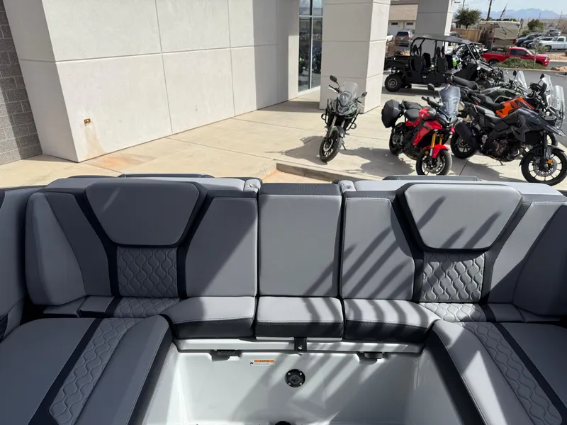 Slide: The Image of 2025 Yamaha Boats 255XD interior with gray seating, motorcycles in the background. - 34