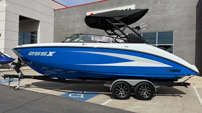 Slide: The Image of 2025 Yamaha Boats 255XD in blue, parked on a trailer outside a building. - 9