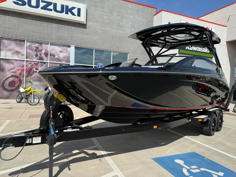 Slide: The Image of 2025 Yamaha Boats 275 SD in black on trailer, parked outside dealership. - 10