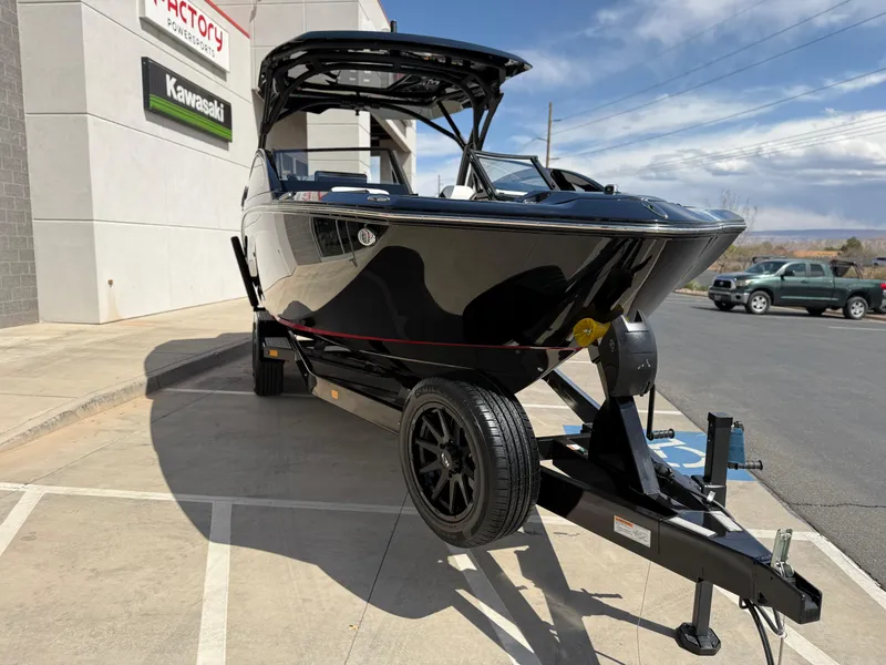 Slide: The Image of 2025 Yamaha Boats 275 SD on trailer, parked outside dealership, sunny day. - 12