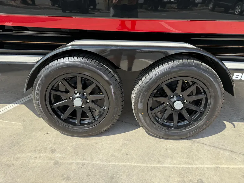 Slide: The Image of 2025 Yamaha Boats 275 SD trailer with dual black wheels and red accent. - 17
