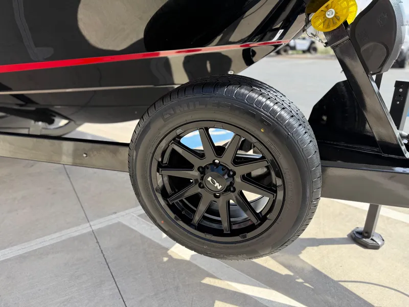 Slide: The Image of 2025 Yamaha Boats 275 SD trailer wheel, black alloy rim, close-up view. - 19