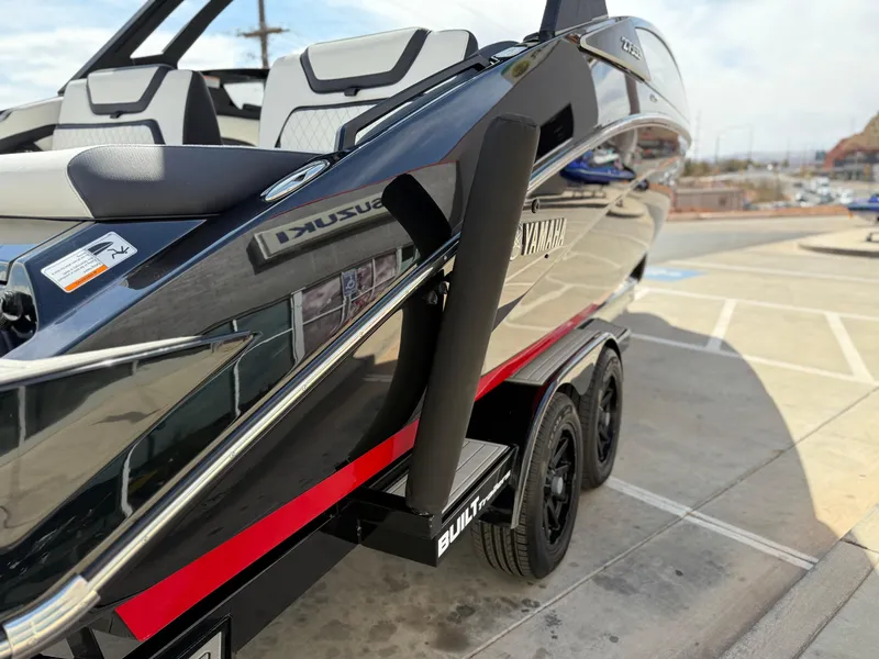 Slide: The Image of 2025 Yamaha Boats 275 SD on trailer, sleek black design with red accents. - 22