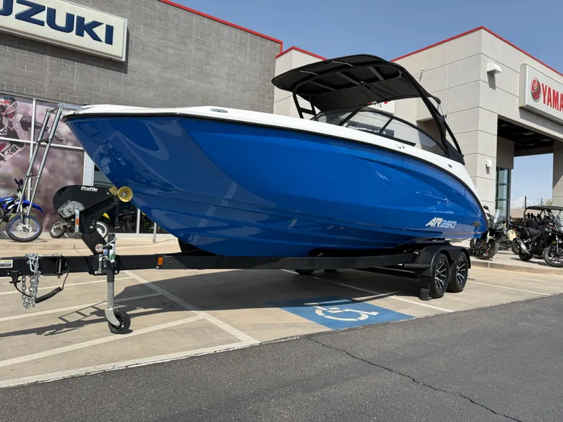 Slide: The Image of 2025 Yamaha Boats AR250 in blue on a trailer outside a dealership. - 15
