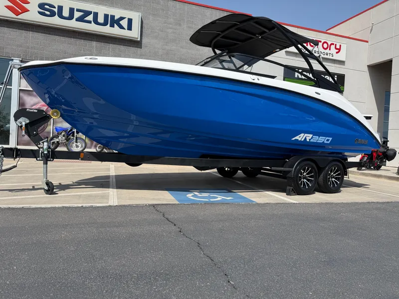 Slide: The Image of 2025 Yamaha Boats AR250 in blue on trailer outside dealership. - 16