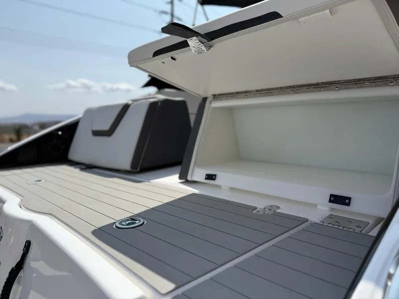 Slide: The Image of 2025 Yamaha Boats AR250 deck with open storage compartment, showcasing sleek design and functionality. - 25