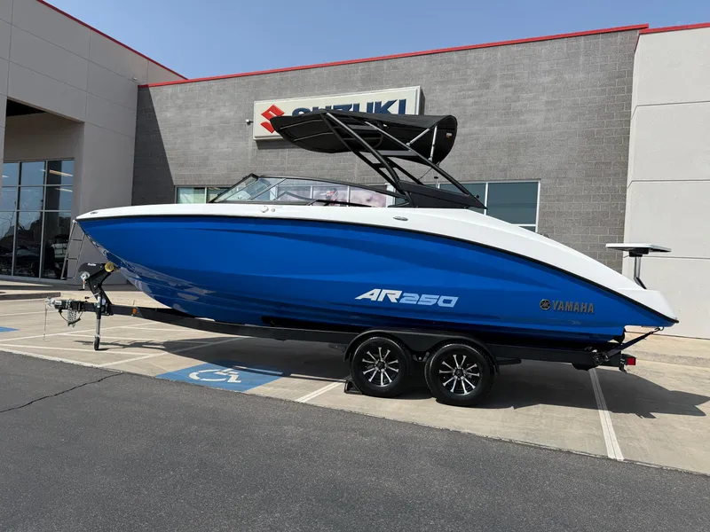 Slide: The Image of 2025 Yamaha Boats AR250 in blue, parked outside a dealership. - 3