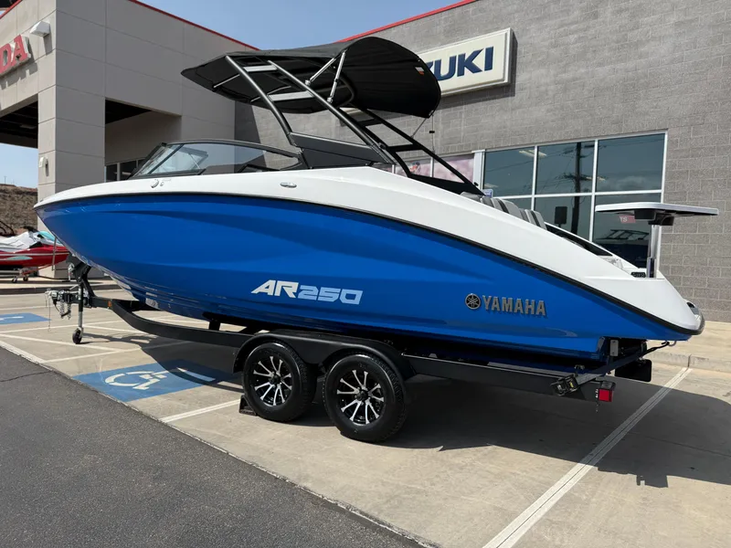 Slide: The Image of 2025 Yamaha AR250 boat in blue, parked on a trailer outside a dealership. - 4