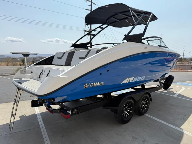 Slide: The Image of 2025 Yamaha AR250 boat on trailer, blue and white design, outdoor display. - 8