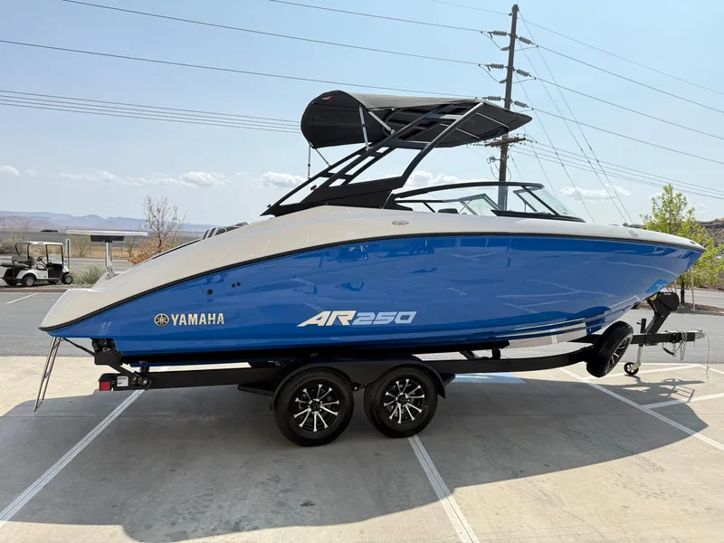 Slide: The Image of 2025 Yamaha AR250 boat in blue, parked on a trailer, side view. - 9