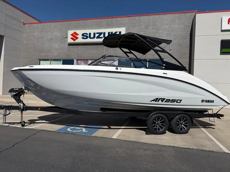 Slide: The Image of 2025 Yamaha Boats AR250 on trailer outside Suzuki dealership. - 11