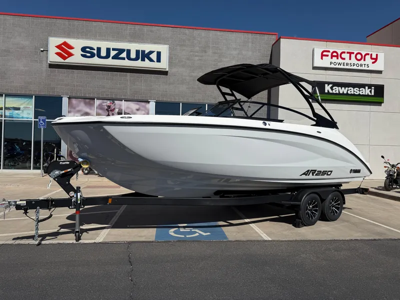 Slide: The Image of 2025 Yamaha Boats AR250 on trailer outside dealership, featuring sleek white design. - 12