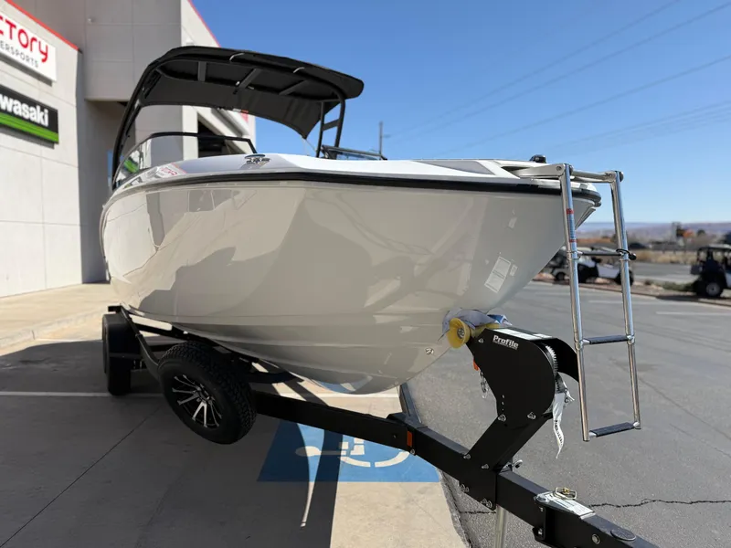 Slide: The Image of 2025 Yamaha Boats AR250 on trailer, displayed outdoors near dealership. - 24