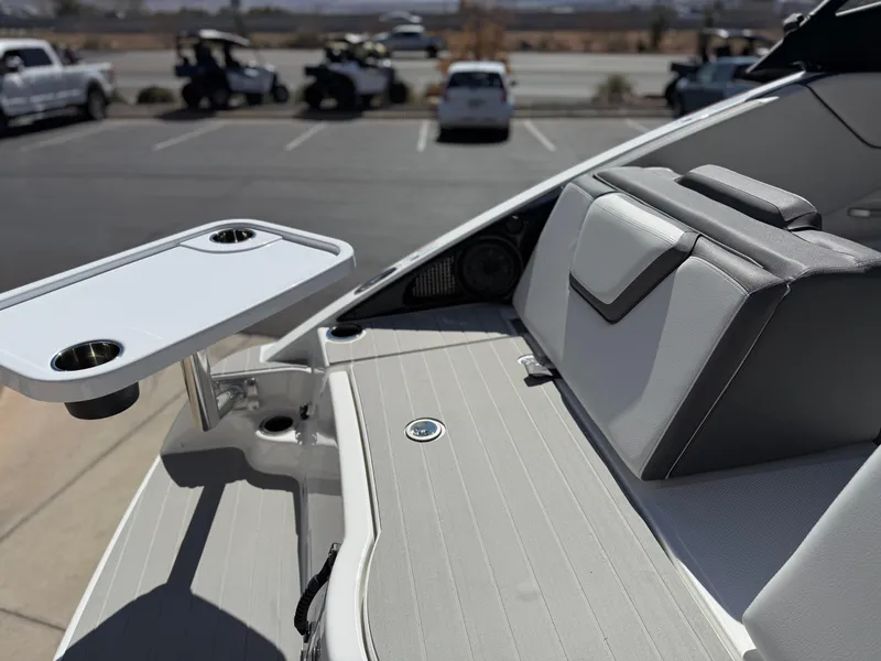 Slide: The Image of 2025 Yamaha Boats AR250 interior with seating and table in a parking lot setting. - 31