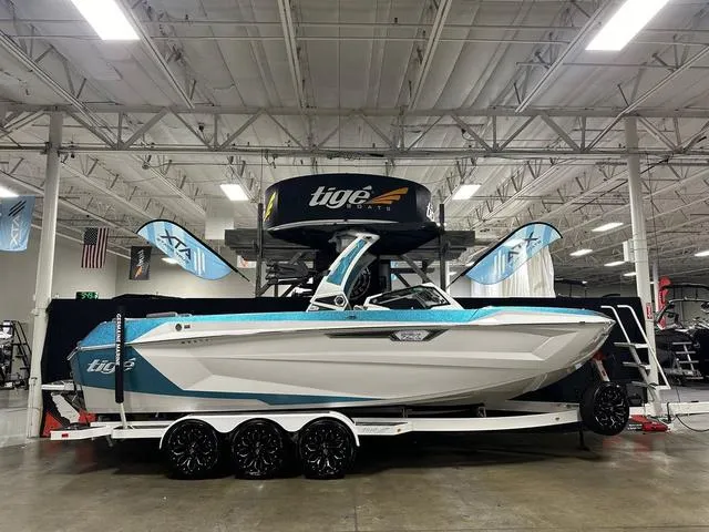 Slide: The Image of 2025 Tigé 25ZX boat displayed indoors on a trailer. - 1