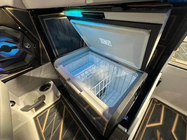 Slide: The Image of 2025 Tigé 25ZX boat interior with open cooler and modern design. - 10