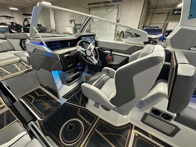 Slide: The Image of 2025 Tigé 25ZX boat interior with modern dashboard and seating in a showroom. - 11