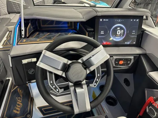 Slide: The Image of 2025 Tigé 25ZX boat dashboard with modern steering wheel and digital display. - 12
