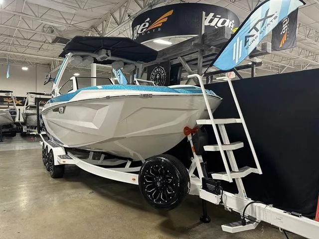 Slide: The Image of 2025 Tigé 25ZX boat on display in showroom with trailer and promotional banners. - 2