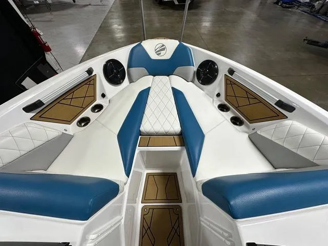 Slide: The Image of 2022 Tigé Z1 boat interior with blue and white seating, cup holders, and speakers. - 16
