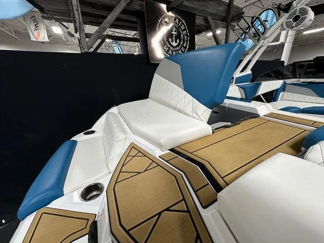 Slide: The Image of 2022 Tigé Z1 boat interior with blue and white seating, wood accents, and modern design. - 7