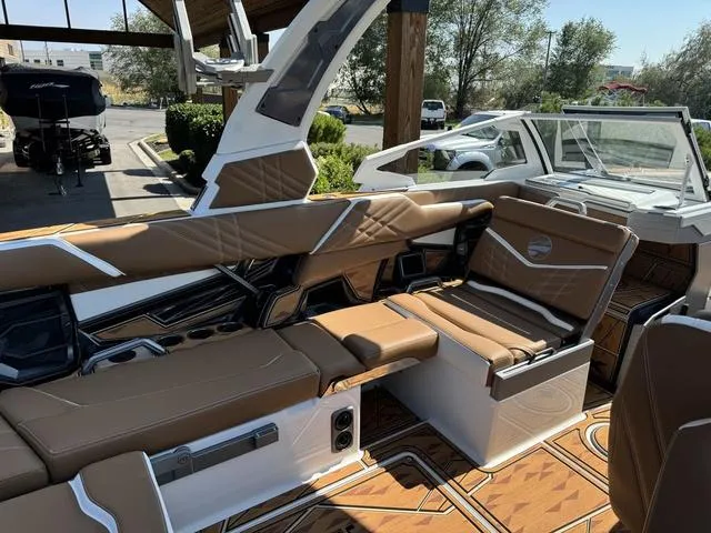 Slide: The Image of 2025 Tigé 23ZX Ultre boat interior with brown leather seating and modern design. - 10