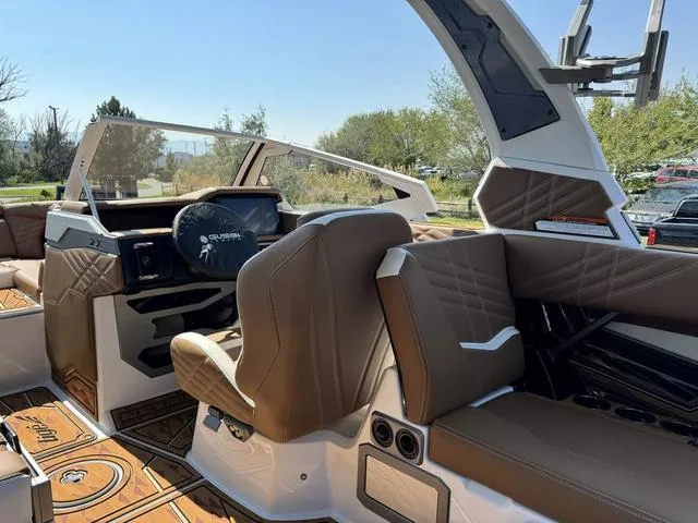 Slide: The Image of 2025 Tigé 23ZX Ultre boat interior with brown leather seats and modern dashboard. - 11
