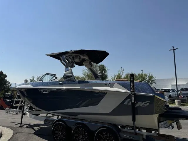 Slide: The Image of 2025 Tigé 23ZX Ultre boat on trailer, sleek design, parked outdoors. - 4