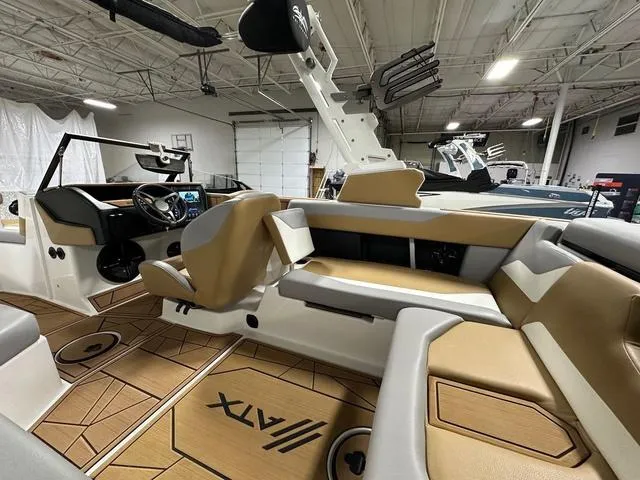 Slide: The Image of 2023 ATX Boats 22 TYPE-S interior with tan seating and modern dashboard in showroom. - 10