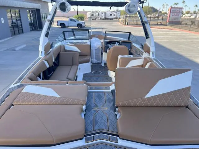 Slide: The Image of 2025 Tigé Z3 boat interior with tan and white seating, docked outdoors. - 12
