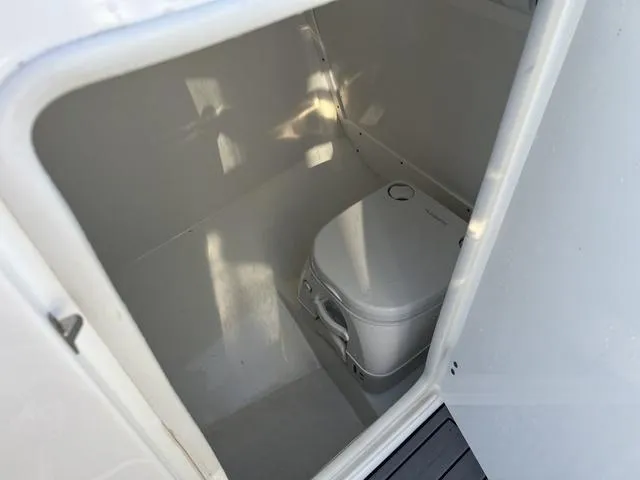 Slide: The Image of 2020 Monterey MX6 SURF boat interior with compact marine toilet. - 12