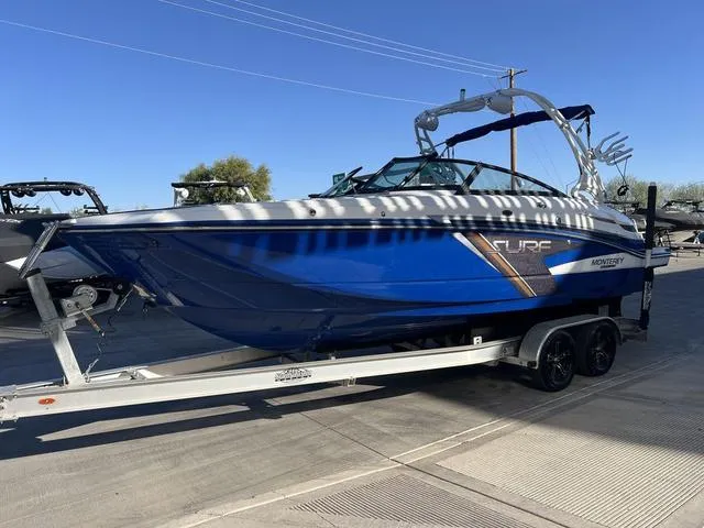 Slide: The Image of 2020 Monterey MX6 SURF boat in blue on a trailer, parked outdoors. - 4