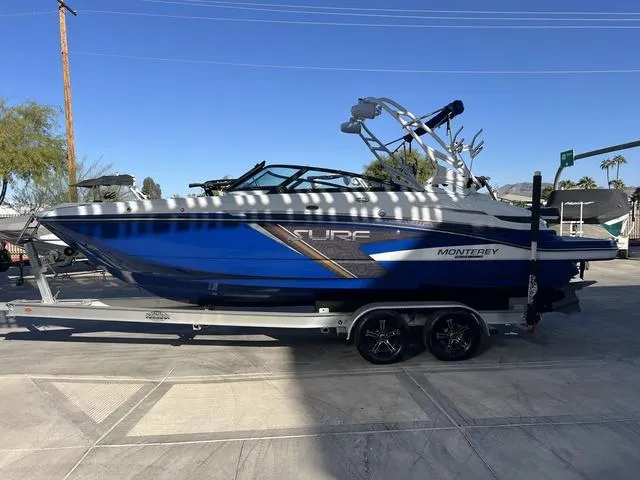 Slide: The Image of 2020 Monterey MX6 SURF boat on trailer, blue and black design, parked outdoors. - 5
