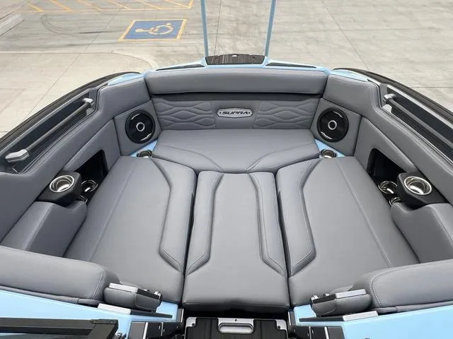 Slide: The Image of 2025 Supra SE 575 boat interior with luxurious gray seating and integrated speakers. - 10