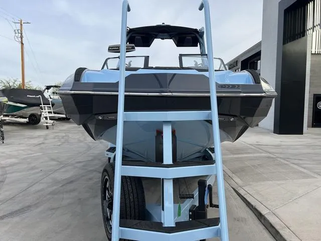 Slide: The Image of 2025 Supra SE 575 boat on trailer, front view, in a dealership lot. - 3