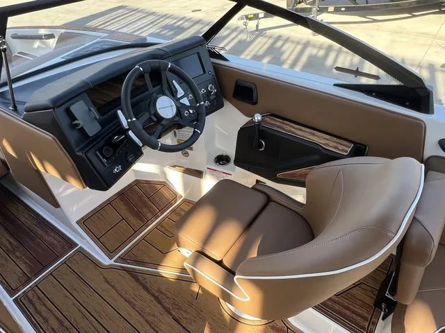 Slide: The Image of Interior of 2025 Moomba Max boat with modern steering and wood accents. - 10