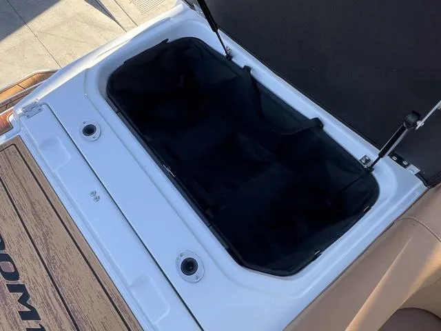 Slide: The Image of 2025 Moomba Max boat storage compartment with open lid, showcasing spacious interior. - 12