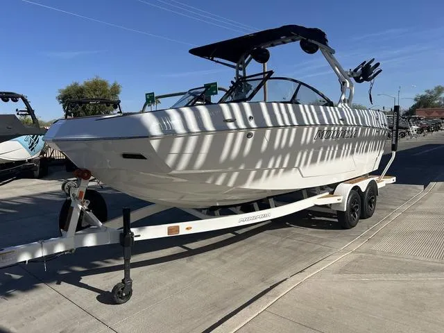 Slide: The Image of 2025 Moomba Max boat on trailer, parked outdoors under clear blue sky. - 4