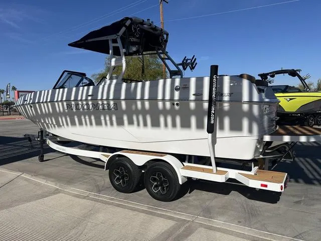 Slide: The Image of 2025 Moomba Max boat on trailer, parked outdoors under clear blue sky. - 6