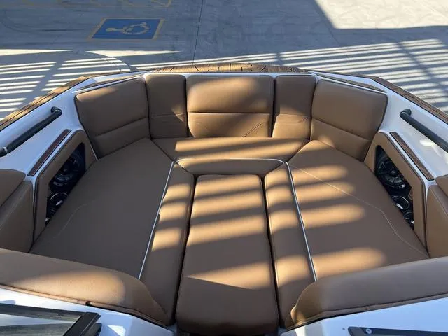 Slide: The Image of 2025 Moomba Max boat interior with brown cushioned seating in sunlight. - 9